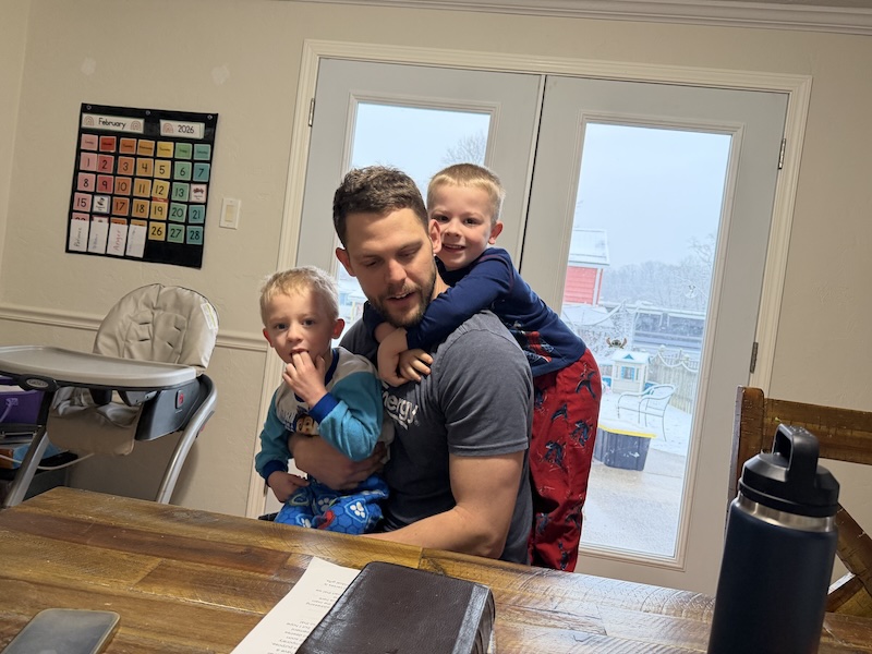 Dad sitting at kitchen table with sons