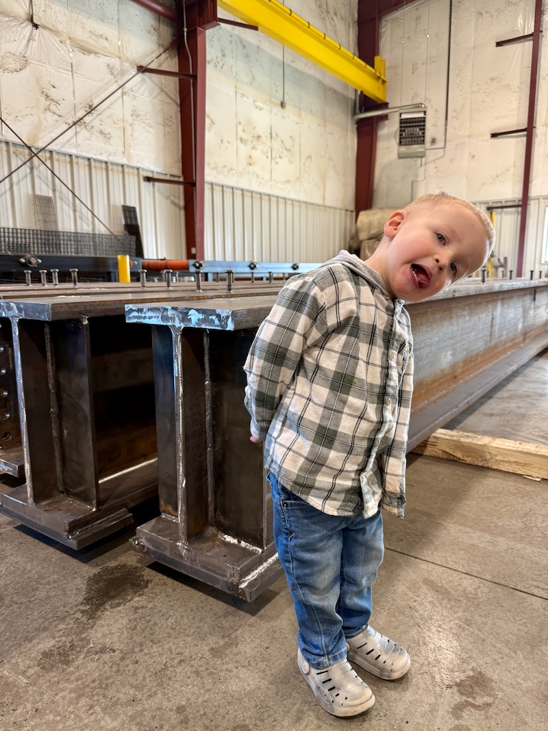 Boy standing by steel beam