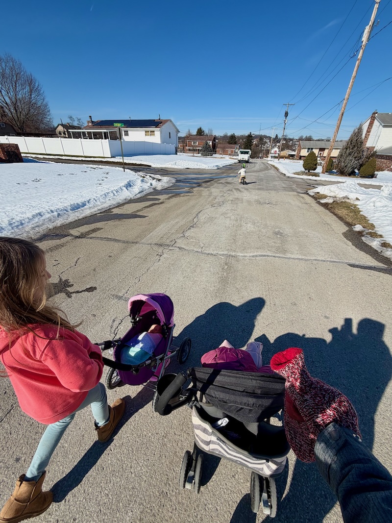 Mom and kids on a walk outside with strollers