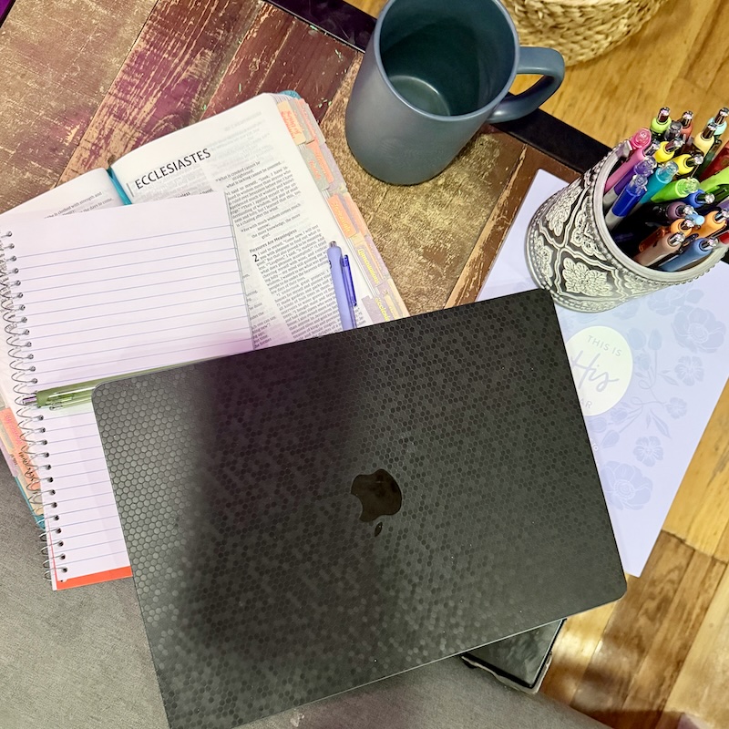 Laptop, Bible, notebook, coffee mug, and pens