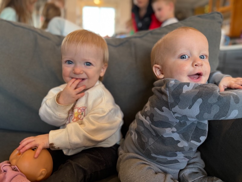 Baby girl and boy sitting on couch