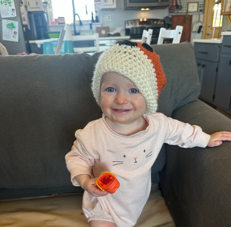 Baby girl on couch with hat
