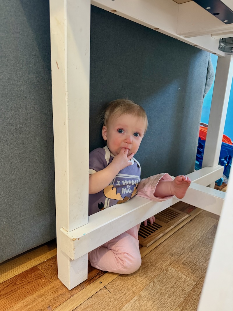 Baby girl stuck under kitchen table