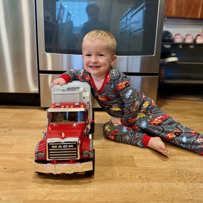 Toddler boy sitting on floor with truck