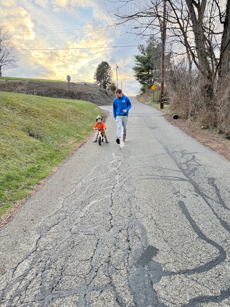 Dad running alongside boy on bike