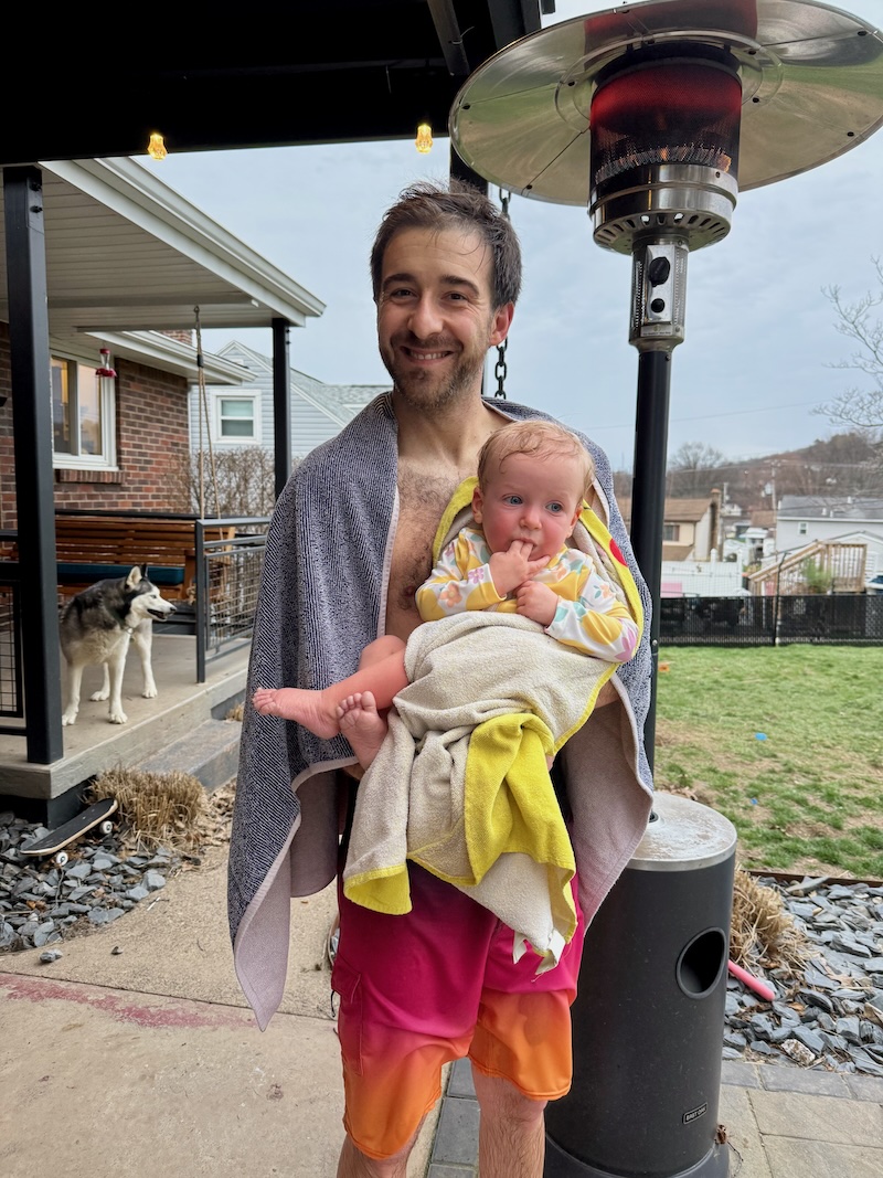Dad holding baby outside in bathing suits