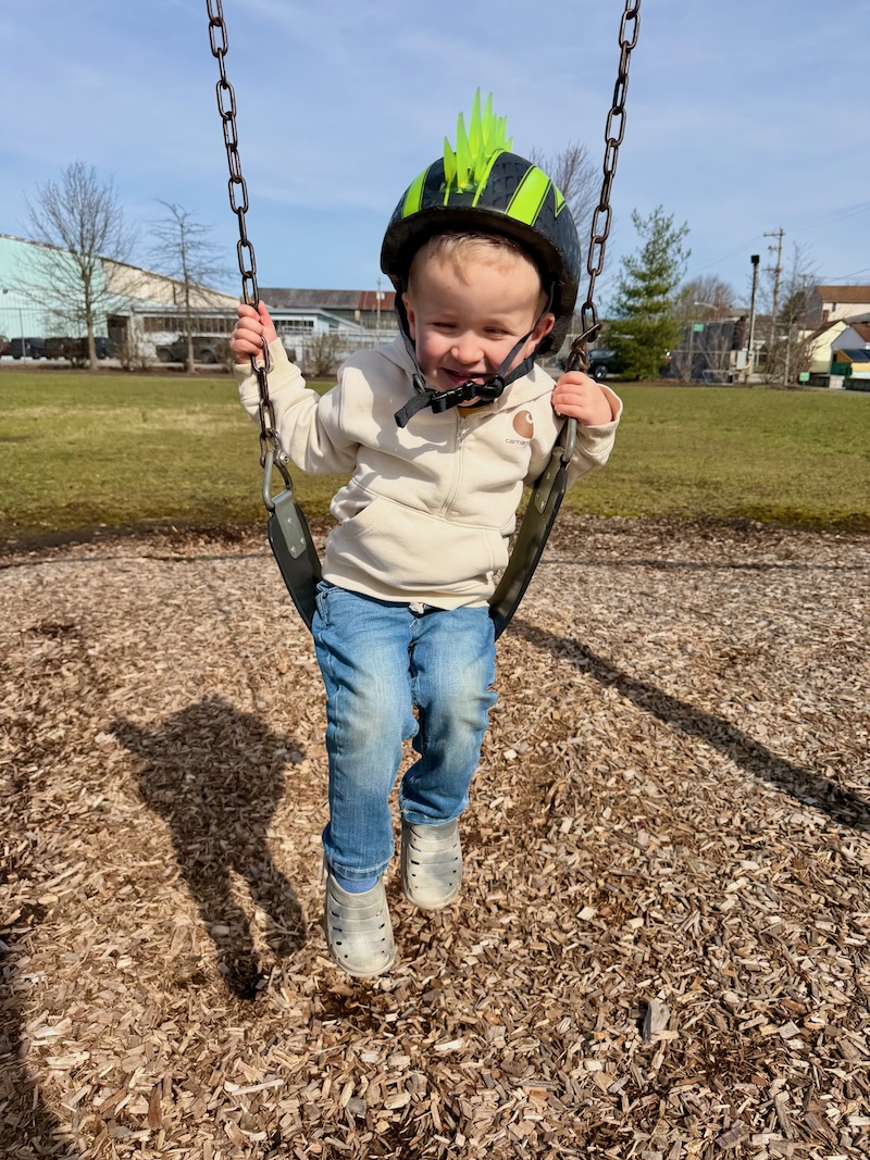 Toddler boy on swing at playground