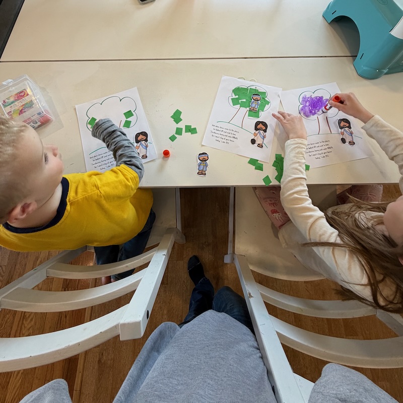 Brother and sister sitting at kitchen table doing Bible craft