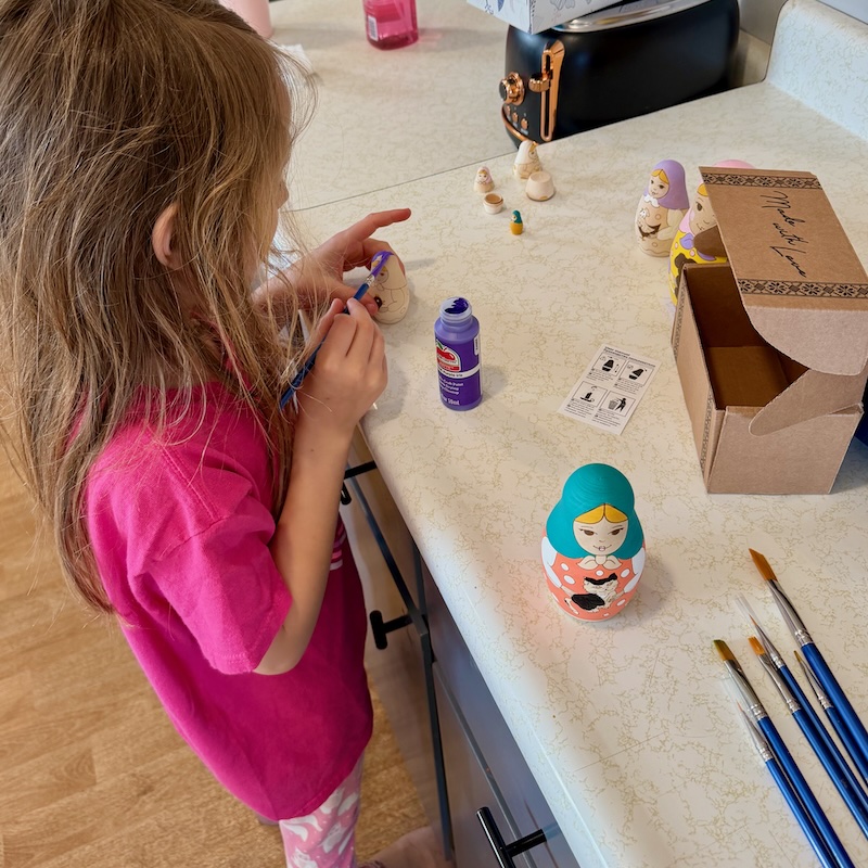 Girl painting Russian nesting dolls