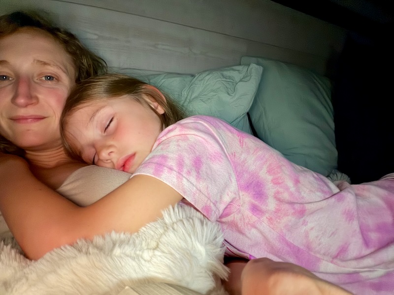 Mom and daughter in bed with daughter sleeping