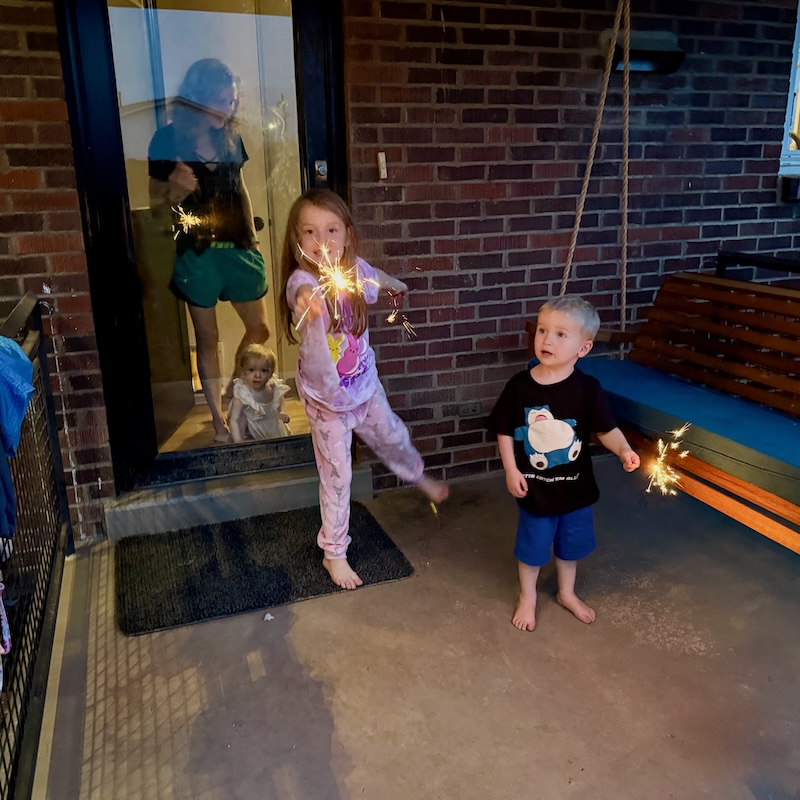 Kids with sparklers on back porch