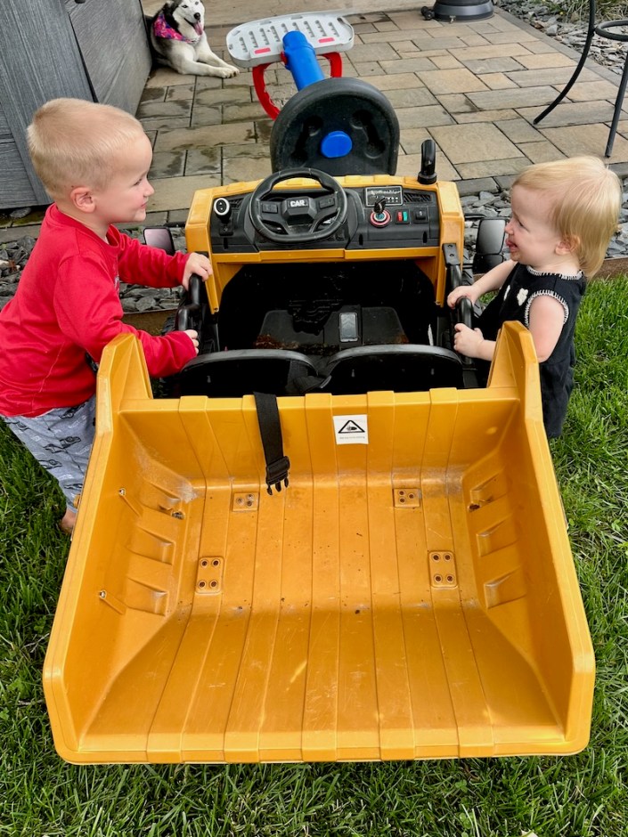 Toddlers playing with toy dump truck together