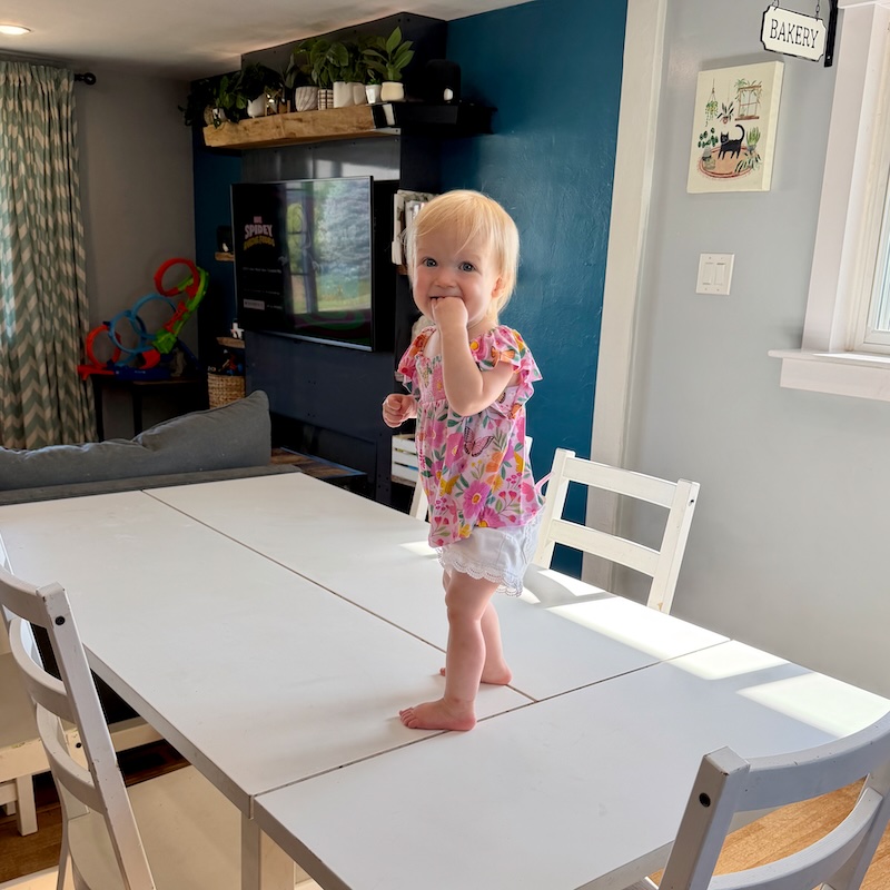 Toddler girl standing on kitchen table