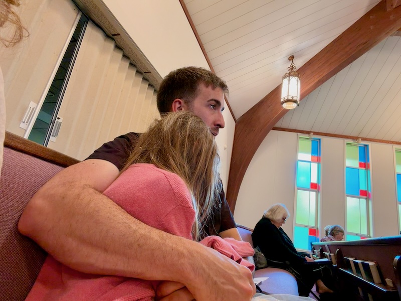 Dad and daughter sitting in church pew