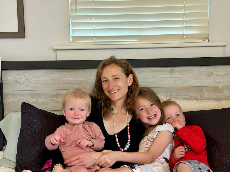Mom and kids sitting on bed