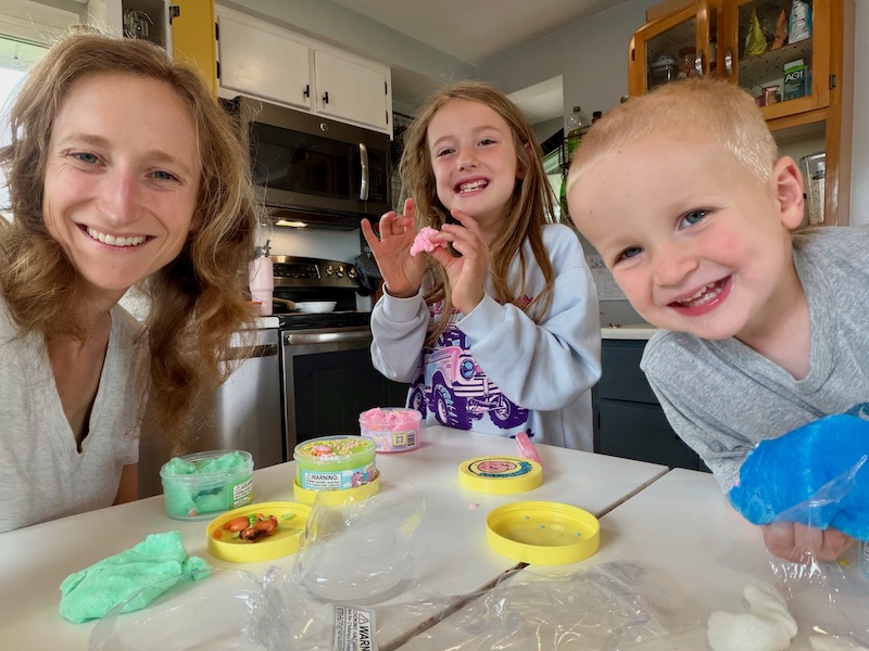 Mom and kids sitting at kitchen table playing with slime