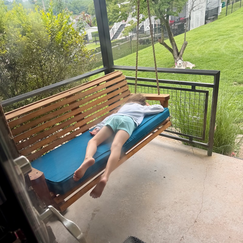 Girl sleeping on porch swing