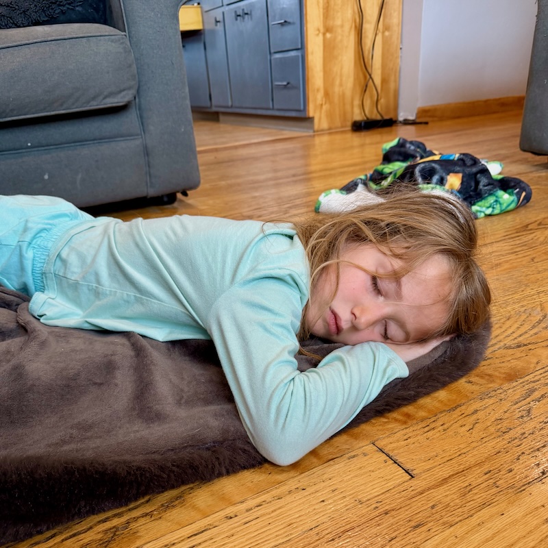 Girl sleeping on blanket on floor