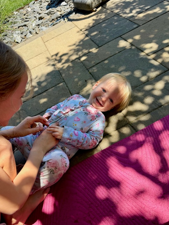 Big sister tickling baby sister
