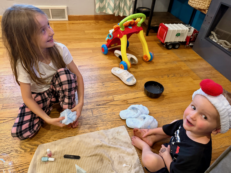 Girl and toddler boy playing spa