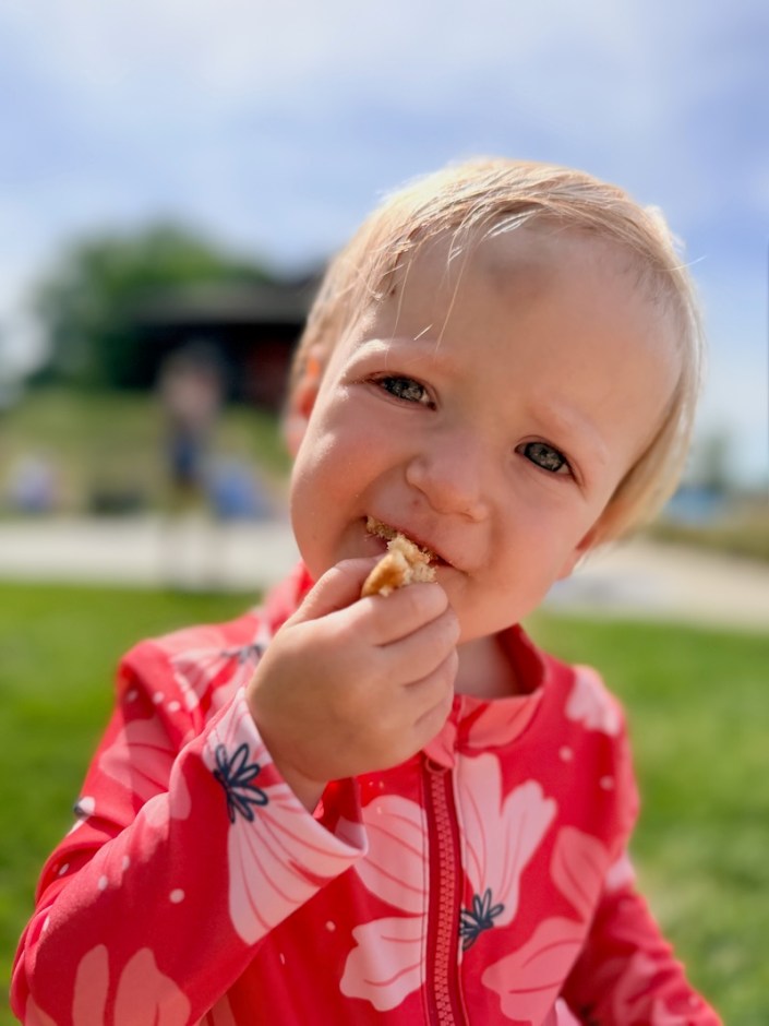 Baby girl eating Nilla wafer at pool