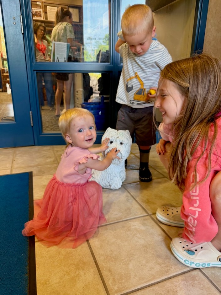 Baby girl petting dog statue