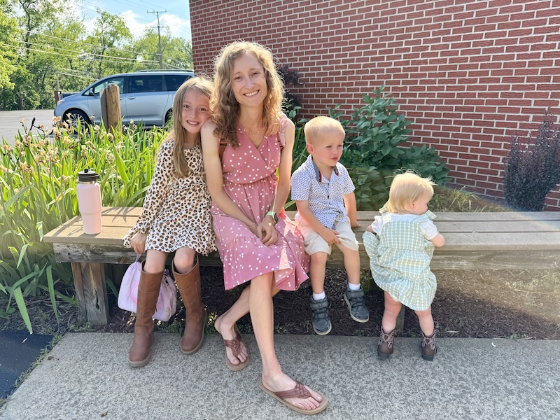 Mom sitting on bench with kids