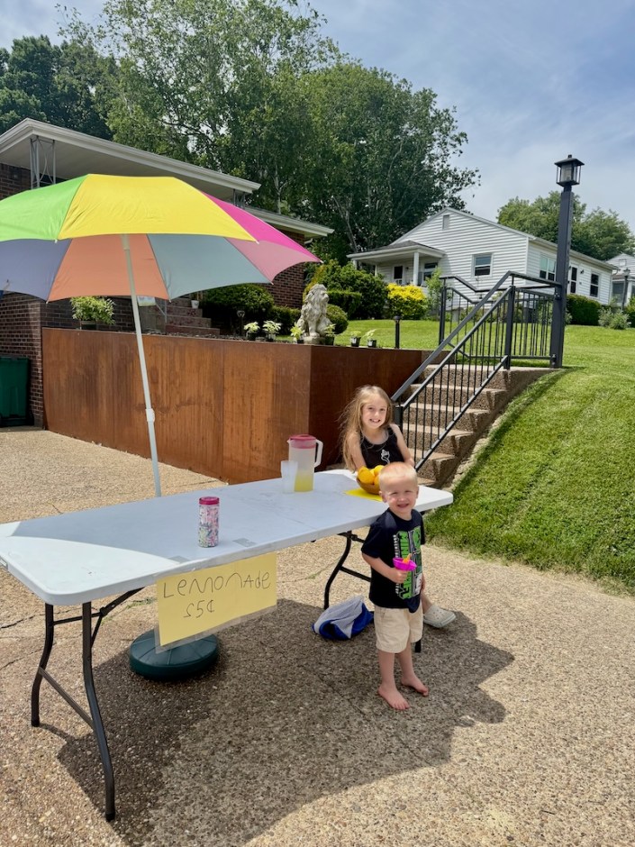 Kids standing by lemonade stand