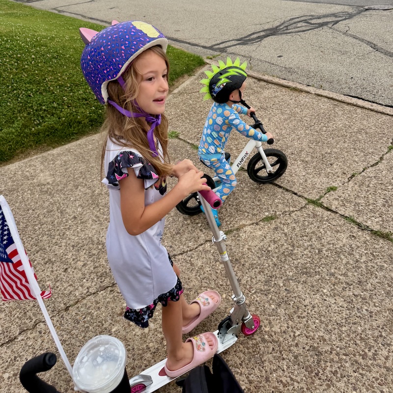 Kids riding bike and scooter on a walk
