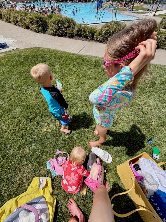 Kids in grass near swimming pool