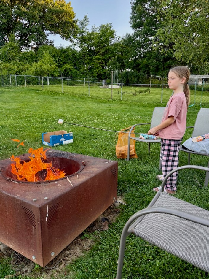 Girl roasting marshmallow over fire