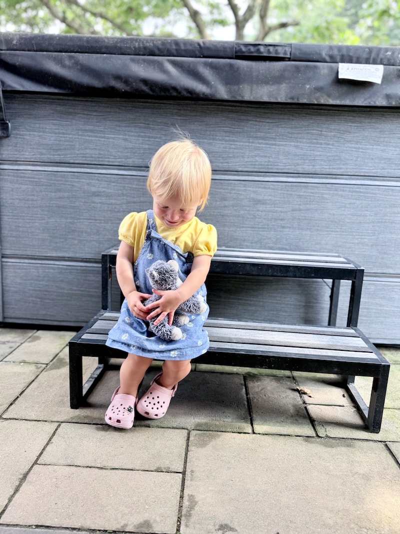 Toddler girl holding cat stuffed toy