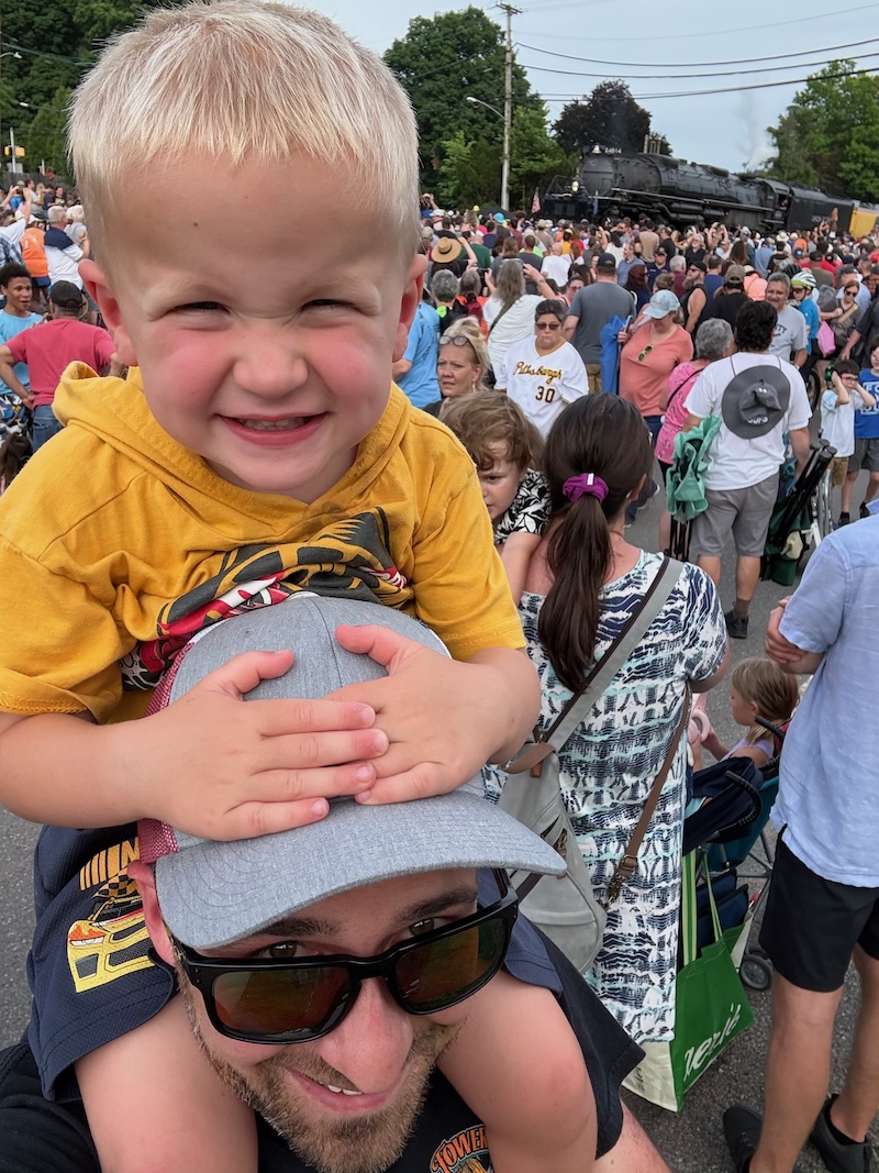 Father and toddler son with Big Boy train behind them