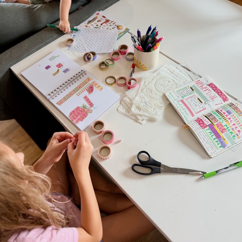 Girl journaling with washi tape and stencils