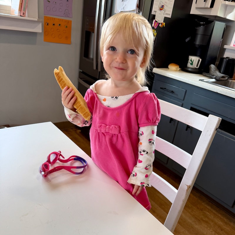 Toddler girl eating a breadstick
