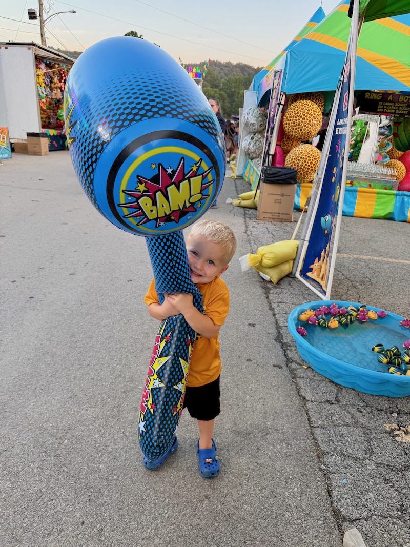 Toddler boy with giant blow up hammer