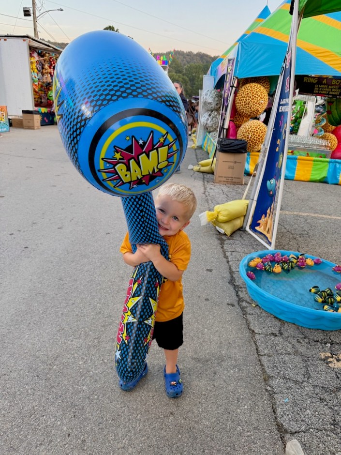 Toddler boy with giant blow up hammer