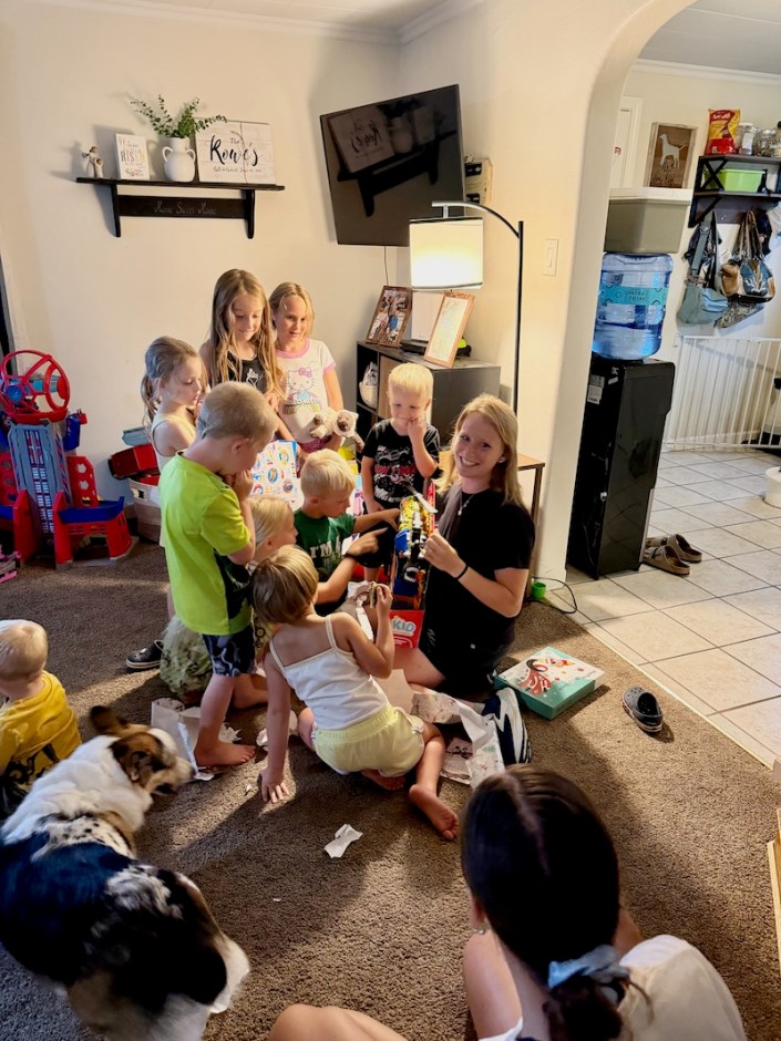 Mom helping kids open birthday gifts