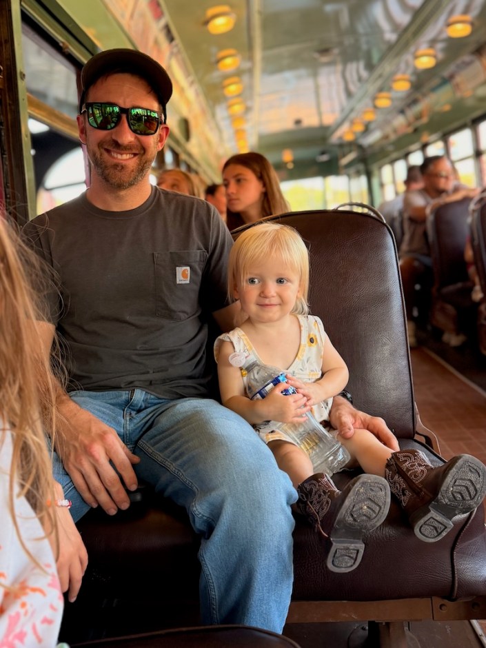 Dad and toddler sitting together on trolley