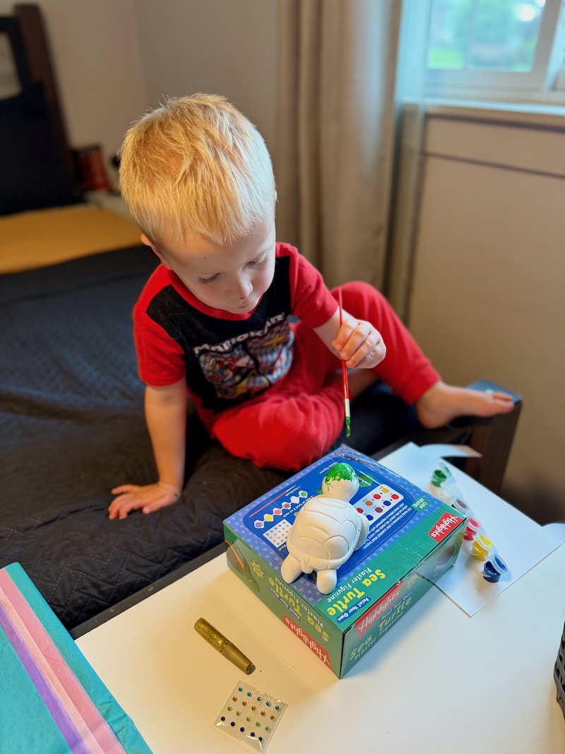 Toddler boy painting a turtle