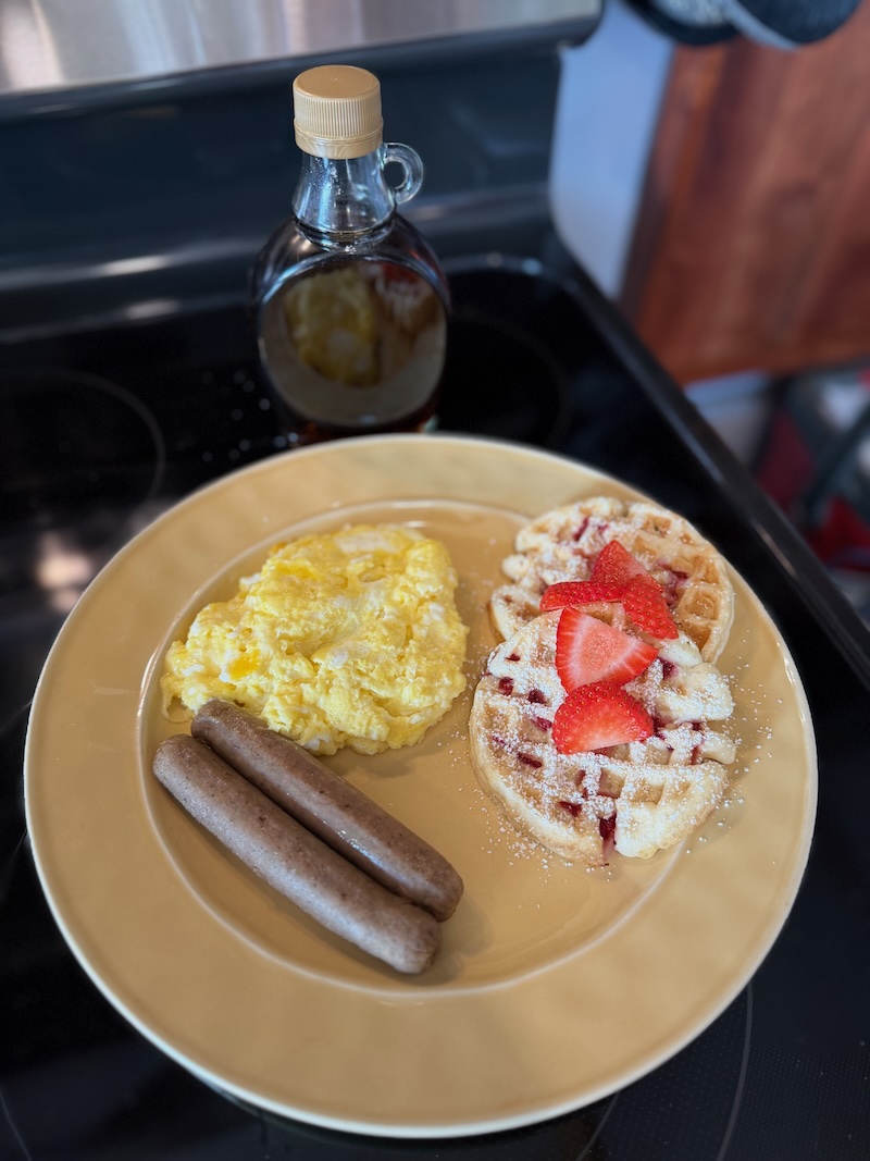 Waffles, sausage, and eggs with maple syrup