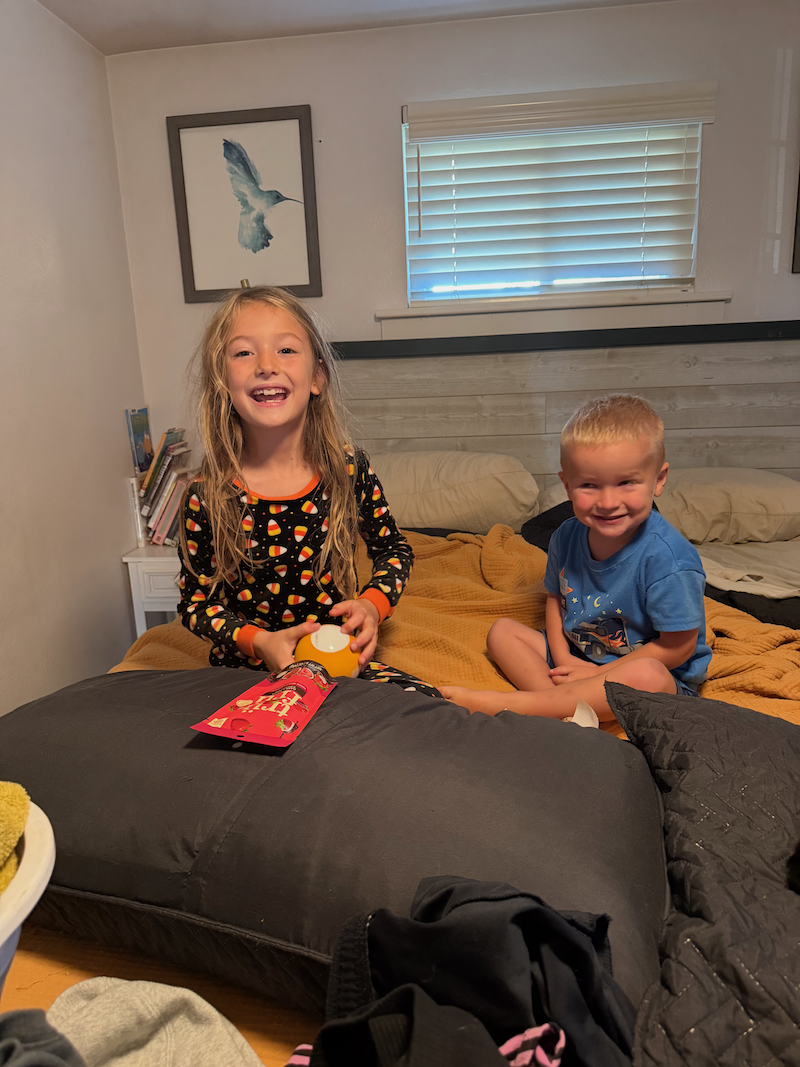 Girl and brother sitting on bed