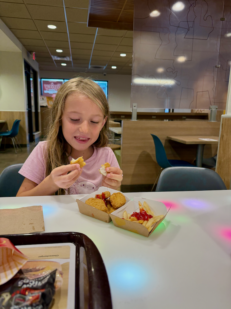 Girl eating chicken nuggets at McDonald's