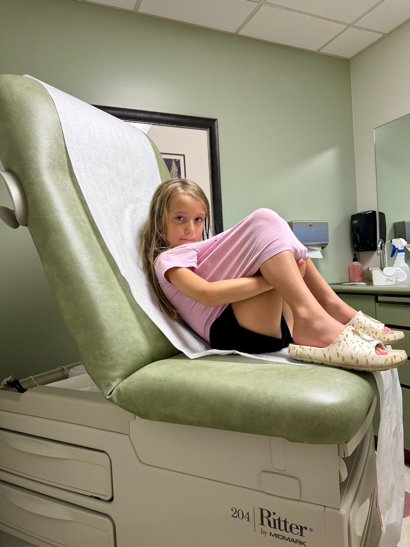 Girl on doctor's office table at Urgent Care