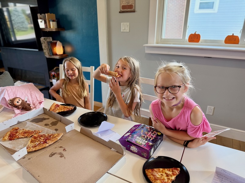 Three girls eating pizza