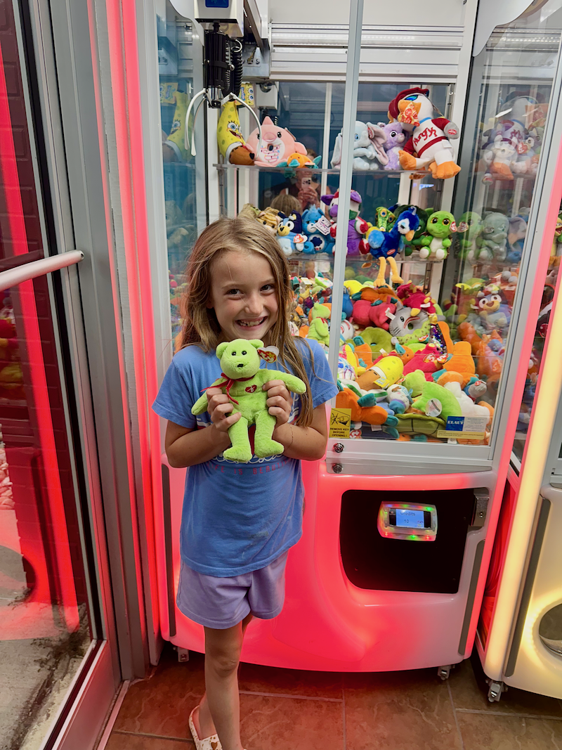 Girl holding a Beanie Baby by claw machine